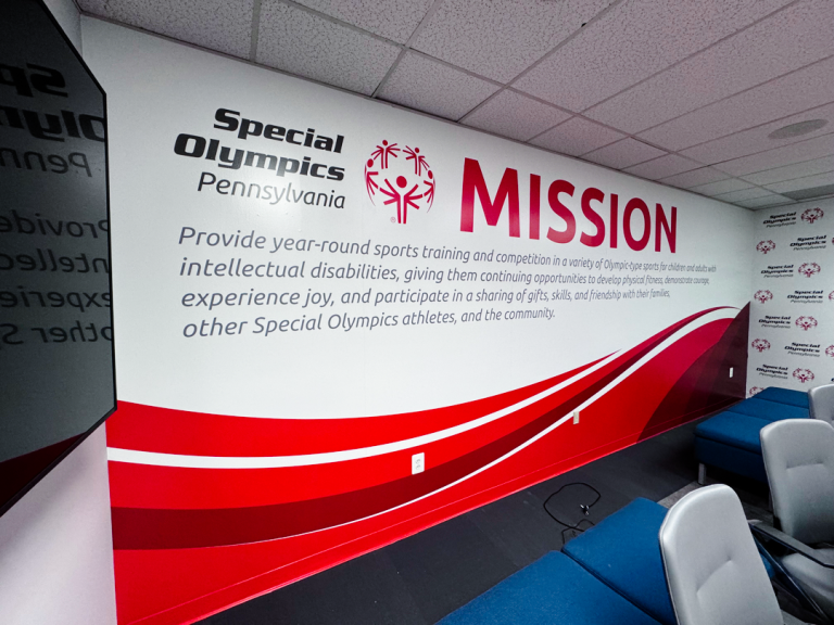 Color Reflections Philly team installs wall-to-ceiling mural for Special Olympics PA office.